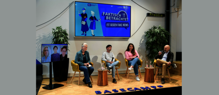 Foto von drei Personen auf der Bühne, die im Rahmen der Telefonica Basecamp Veranstaltung eine Debatte führen.